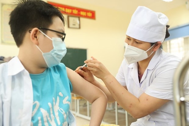 Nhân viên y tế tiêm vaccine phòng Covid-19 cho học sinh lớp 6. (Nguồn: TTXVN)