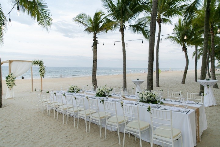 Tiệc cưới có gam màu trắng chủ đạo. Cổng cưới được trang trí hoa tươi đơn giản.