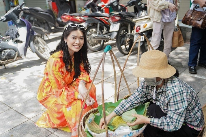 Hoa hậu Indonesia thích thú khi thấy một gánh hàng rong bán cốm trên vỉa hè Hà Nội và bị hấp dẫn bởi mùi thơm của những hạt cốm dẻo vừa ra lò.