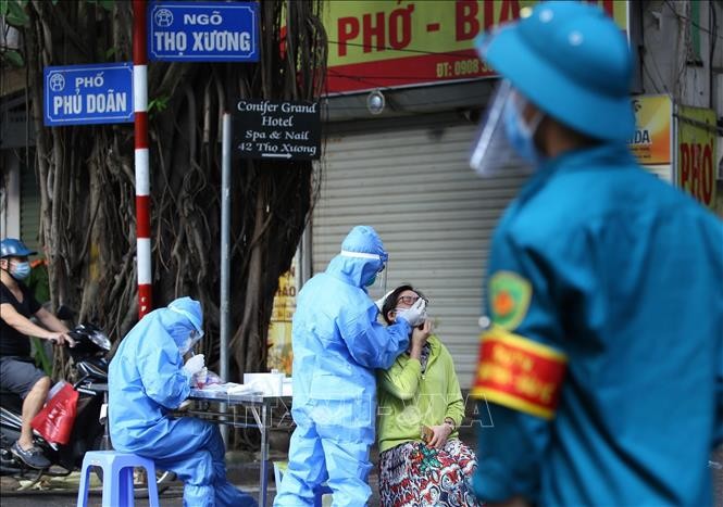 Nhân viên y tế lấy mẫu xét nghiệm Covid-19 cho người dân khu vực lân cận Bệnh viện Việt Đức.
