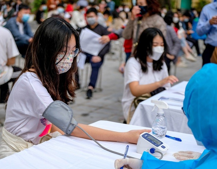 Học sinh Hà Nội kiểm tra sức khỏe khi tiêm vaccine phòng Covid-19. (Nguồn: Dân trí)