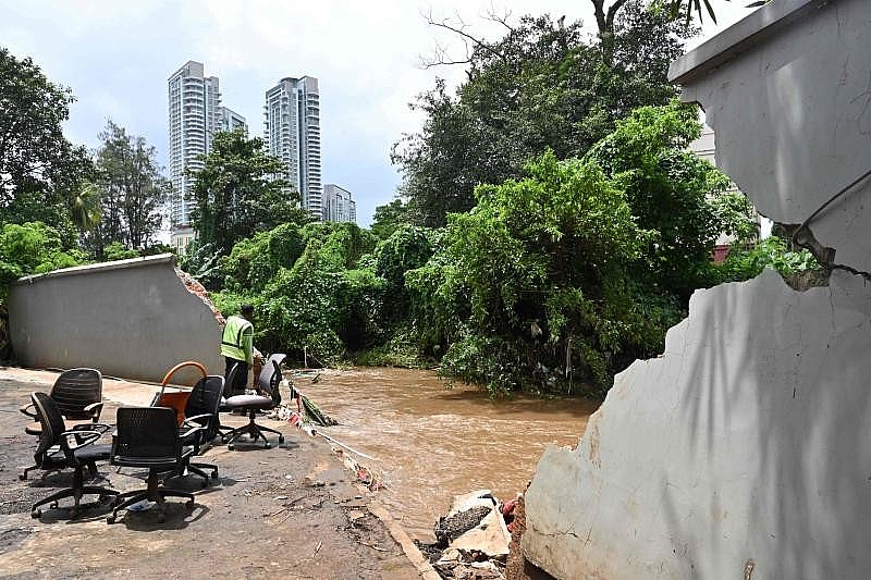 Một người đàn ông nhìn dòng sông Krukut nơi một bờ kè đã xuyên thủng tường, gây ngập lụt khu vực, ở Kemang, Jakarta. (Nguồn: AFP) 