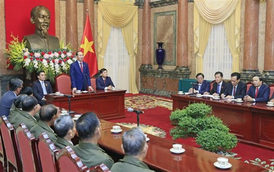 president receives lao people with contributions to vietnam revolution