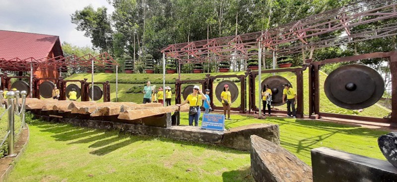Thành viên Nhóm thiện nguyện ghi lại khoảnh khắc lưu niệm với bộ cồng chiêng và đàn đá khổng lồ tại Khu bảo tồn (Ảnh: TQD).