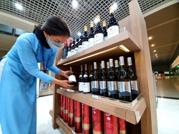 A staff arranges goods at a duty free store at the Tan Son Nhat airport as it prepares to welcome international tourists. (Photo tuoitre.vn)