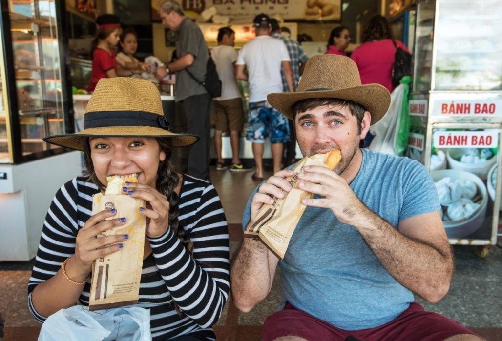 Foreign visitors enjoy Banh Mi- a Vietnamese sandwich (Photo: Intrepid/TheTimes)