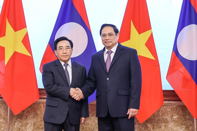 Prime Minister Pham Minh Chinh (right) shakes hands with Lao counterpart Phankham Viphavanh before co-chairing the at the 44th meeting of the Viet Nam-Laos Intergovernmental Committee at the Government Office, Ha Noi, January 10, 2022. Photo: VGP