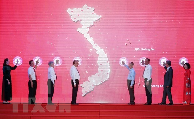 President Nguyen Xuan Phuc (fourth from left) and delegates launch the Humanitarian Month (Photo: VNA)