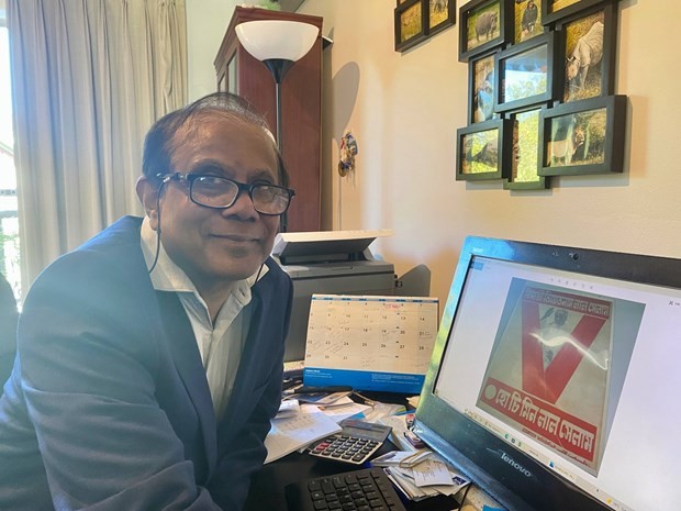 Journalist Sandip Hor and a photo of the historic President Ho Chi Minh poster. (Photo: broadcast by VNA)