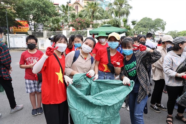 A group of young volunteers prepare to collect the trash after receiving their equipment. — VNS Photo 