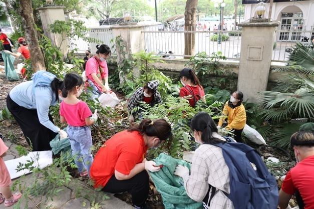 Volunteers clear out trash from a moat-like structure that turned into a makeshift landfill. — VNS Photo