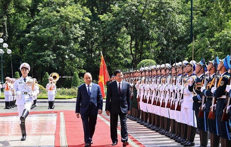 Chủ tịch nước Nguyễn Xuân Phúc và Tổng Bí thư Ban Chấp hành Trung ương Đảng Nhân dân Cách mạng Lào, Chủ tịch nước Cộng hòa Dân chủ Nhân dân Lào Thongloun Sisoulith duyệt Đội danh dự Quân đội nhân dân Việt Nam ngày 28/6. (Nguồn: TTXVN)