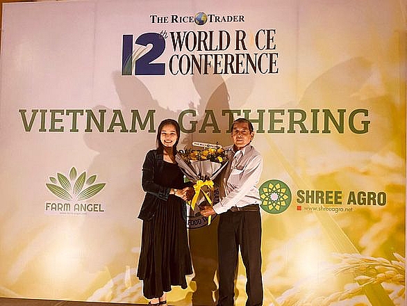 Cha đẻ gạo thơm ST25 - kỹ sư Hồ Quang Cua (phải) nhận hoa chúc mừng từ đại diện Ban tổ chức. (Nguồn: NVCC)