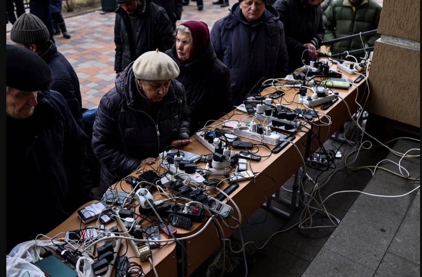 Người dân tranh thủ sạc pin cho thiết bị di động trong một tòa nhà công cộng ở Bucha, phía Tây Bắc Kiev, Ukraine, ngày 6/4. (Nguồn: Getty)