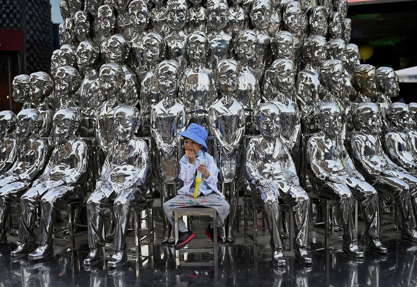 Cậu bé ngồi trên chiếc ghế giữa các tác phẩm điêu khắc được trưng bày tại một trung tâm mua sắm vào Ngày Quốc tế Thiếu nhi ở Bắc Kinh, Trung Quốc, ngày 1/6. 