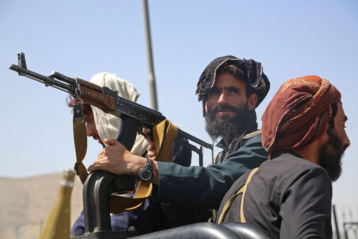 Các chiến binh Taliban canh gác trên đường phố ở Kabul, Afghanistan, ngày 16/8, sau khi lực lượng này nhanh chóng giành quyền kiểm soát gần như toàn bộ đất nước, kết thúc cuộc chiến kéo dài 20 năm. Trong khi đó, hàng nghìn người dân cố gắng chạy ra sân ba