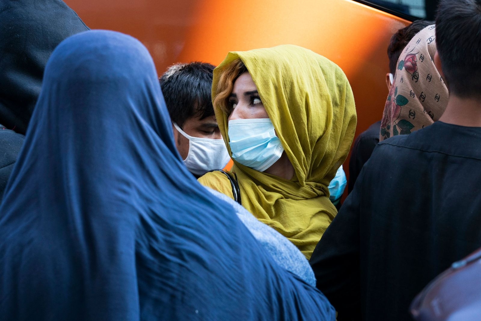 Người dân chạy trốn khỏi Kabul, Afghanistan, chờ lên xe buýt ở Chantilly, Virginia, Mỹ sau khi họ đến Sân bay Quốc tế Washington Dulles, ngày 25/8. (Nguồn: AP)