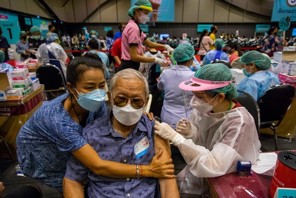 Cô con gái ôm người cha của mình khi ông được tiêm liều vaccine Covid-19 đầu tiên tại một trung tâm mua sắm ở Bangkok, Thái Lan, ngày 30/8. (Nguồn: Getty)