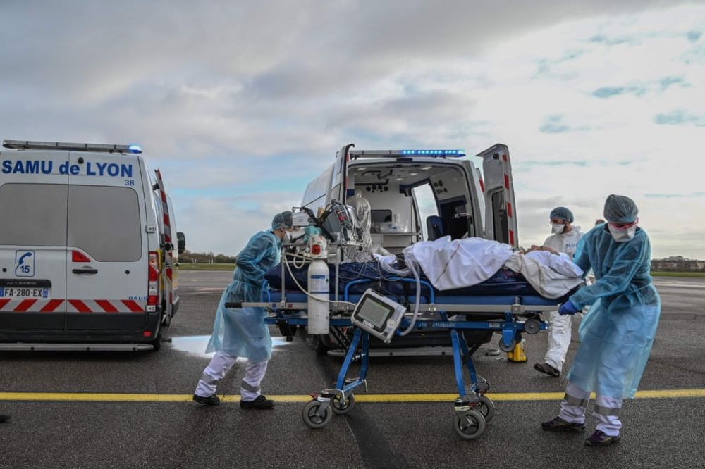 Nhân viên y tế mặc trang phục bảo hộ cá nhân khi vận chuyển bệnh nhân đến chuyến bay y tế đang chờ ở sân bay Bron, Lyon, Pháp, trong bối cảnh đại dịch Covid-19 hoành hành tại quốc gia châu Âu. Getty