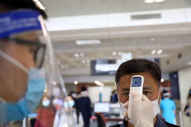 A man gets temperature check before getting on a flight at Noi Bai International Airport in Hanoi (Photo: VNA)