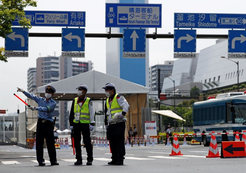 Các nhân viên  an ninh đứng gác ở lối vào của Làng vận động viên Olympic Tokyo ngày 13/7. (Nguồn Reuters)