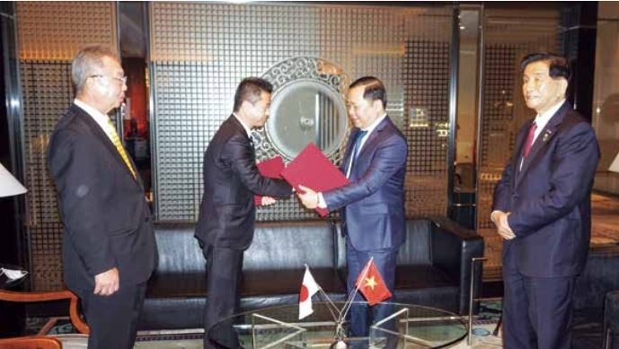 Mr. Nguyen Phi Long, Chairman of Binh Dinh Provincial People's Committee (second from right) and Mr. Nakai Akimoto, Head of Yoshino town, Nara province, Japan awarded a Memorandum of Understanding on cooperation orientation. (Photo: H.L)