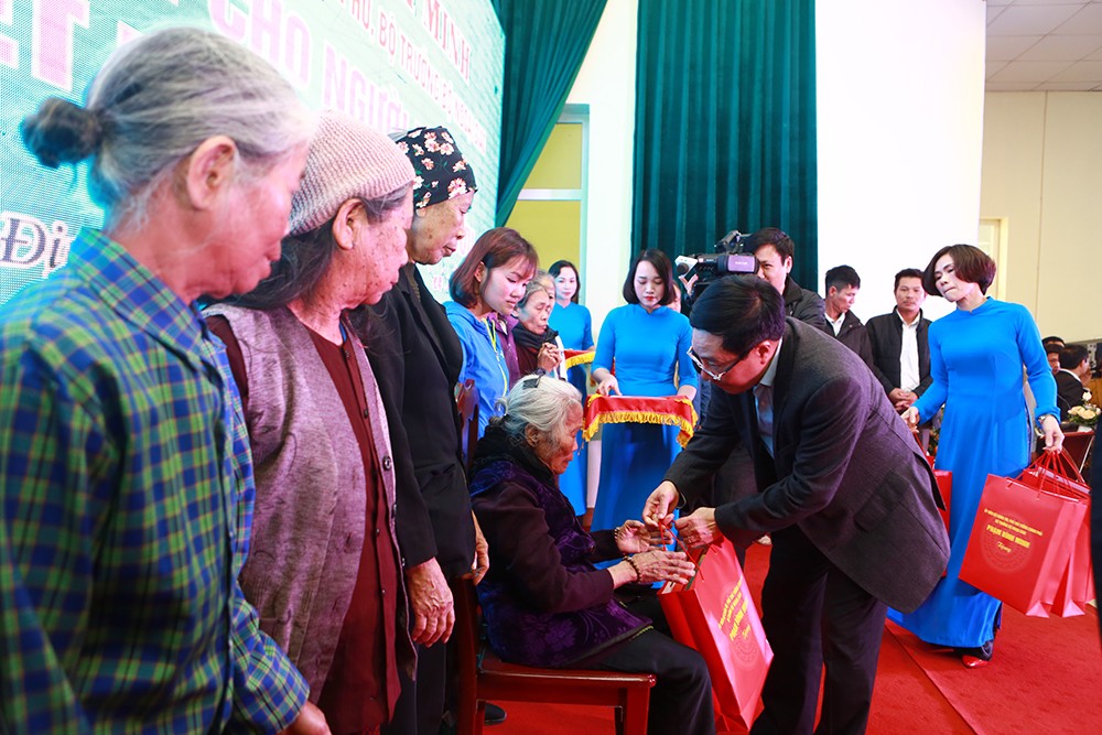 Phó Thủ tướng Phạm Bình Minh tặng quà Tết cho các hộ nghèo. (Ảnh VGP/Hải Minh)