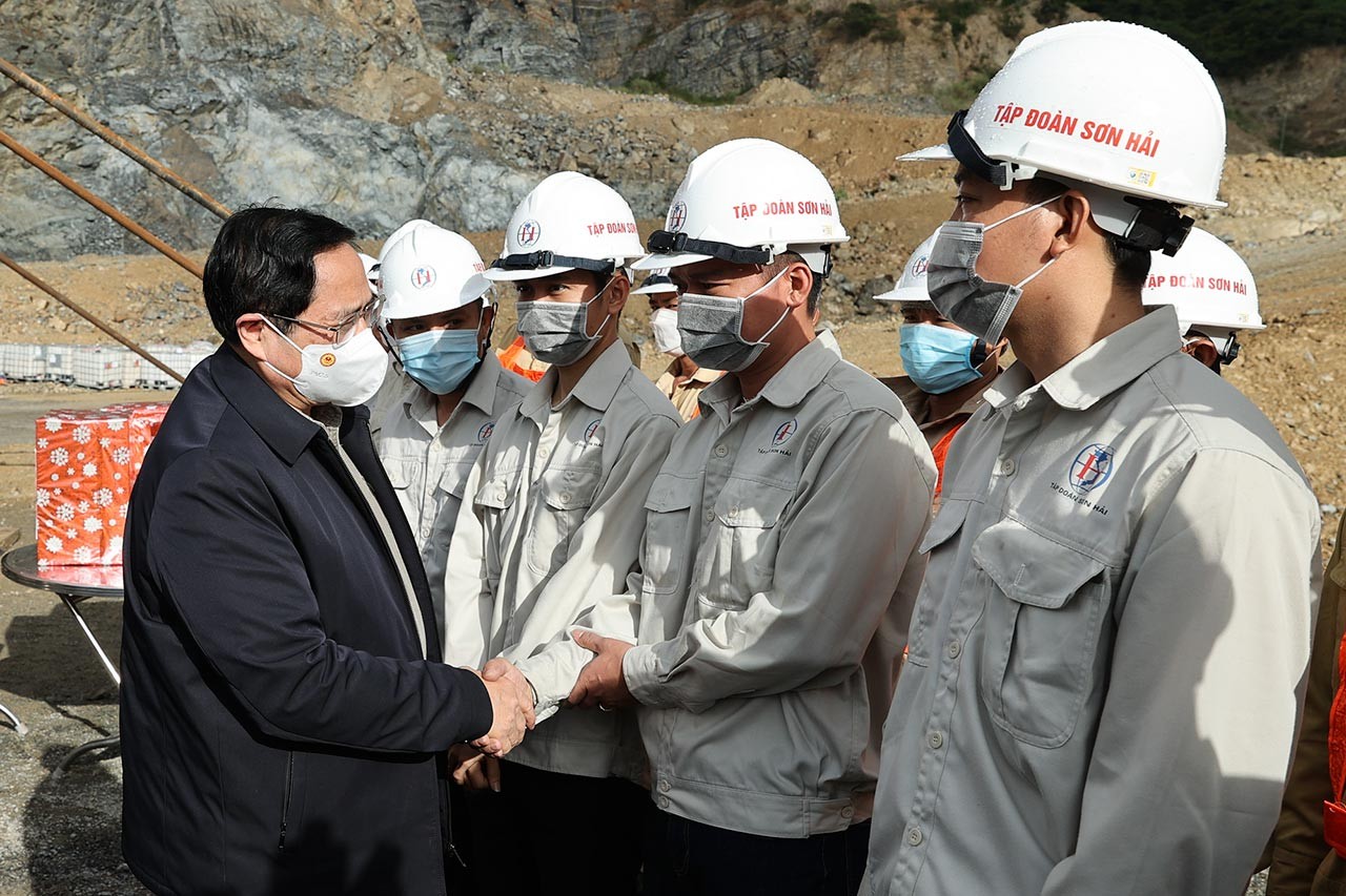 Thủ tướng Phạm Minh Chính chúc Tết cán bộ kỹ sư, công nhân, người lao động làm việc xuyên Tết Trên tuyến tại cửa hầm đường bộ qua núi Dốc Sạn. (Nguồn: VGP/Nhật Bắc)