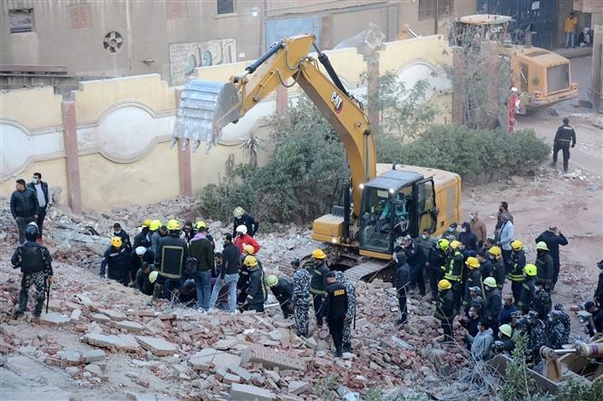 Lực lượng cứu hộ và tình nguyện viên tìm kiếm các nạn nhân tại hiện trường vụ sập toà nhà 10 tầng ở quận Gesr Giza, Cairo (Ai Cập) ngày 27/3/2021. (Ảnh: AFP/TTXVN)