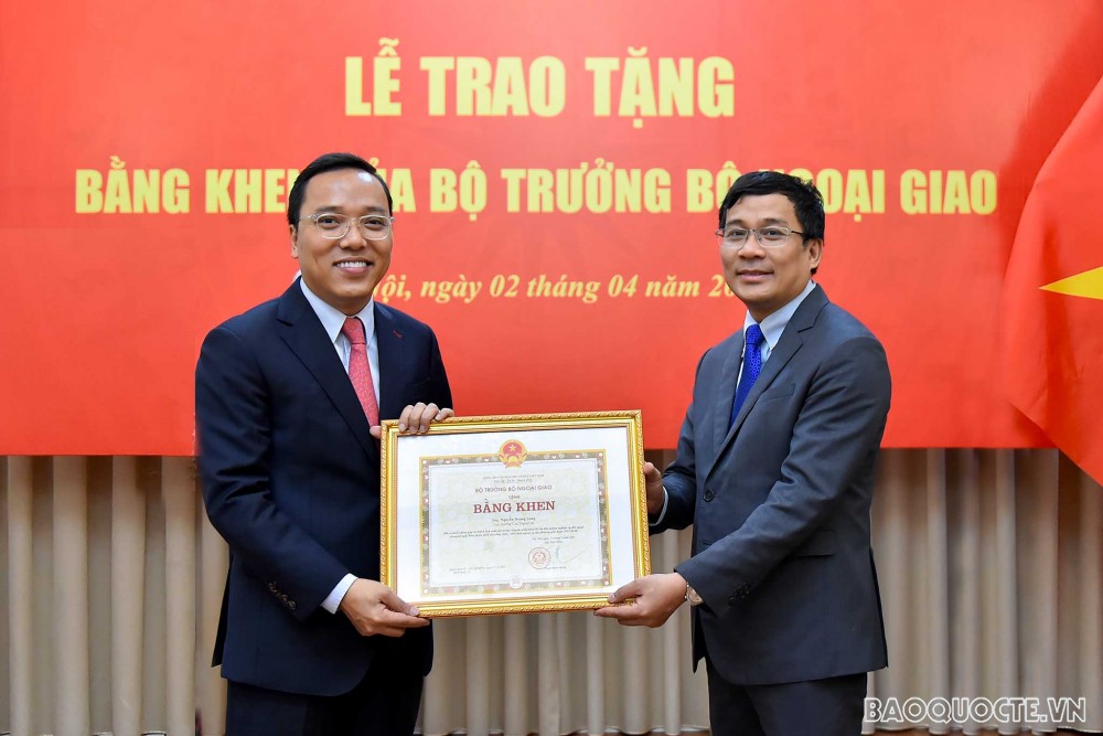 Thứ trưởng Ngoại giao Nguyễn Minh Vũ trao Bằng khen của Bộ trưởng Ngoại giao cho ông Nguyễn Hoàng Long, nguyên Cục trưởng Cục Ngoại vụ. 