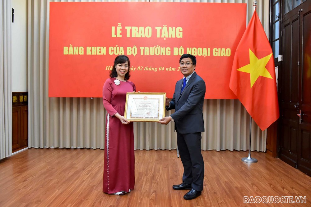 Thứ trưởng Ngoại giao Nguyễn Minh Vũ trao Bằng khen của Bộ trưởng Ngoại giao cho bà Ngô Mai Anh, Chuyên viên Trung tâm Biên phiên dịch Quốc gia.