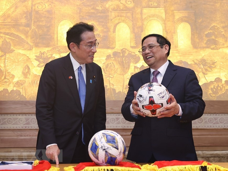 Thủ tướng Phạm Minh Chính và Thủ tướng Nhật Bản Kishida Fumio với tặng phẩm là hai quả bóng có chữ ký của đội tuyển bóng đá hai nước. (Nguồn: TTXVN)