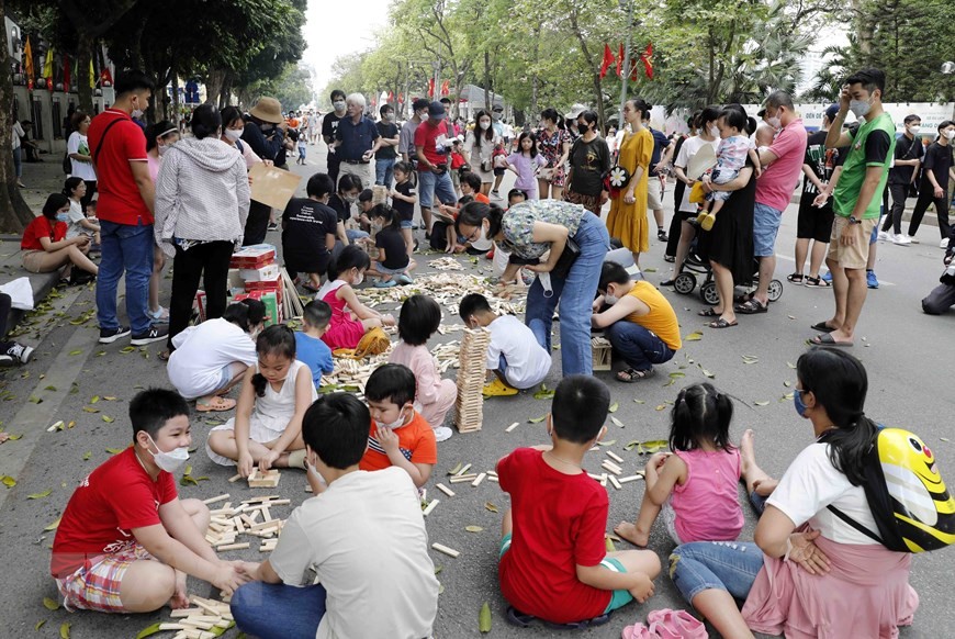 Các em nhỏ vui chơi xếp gỗ trên phố Đinh Tiên Hoàng. (Ảnh: Trần Việt/TTXVN)
